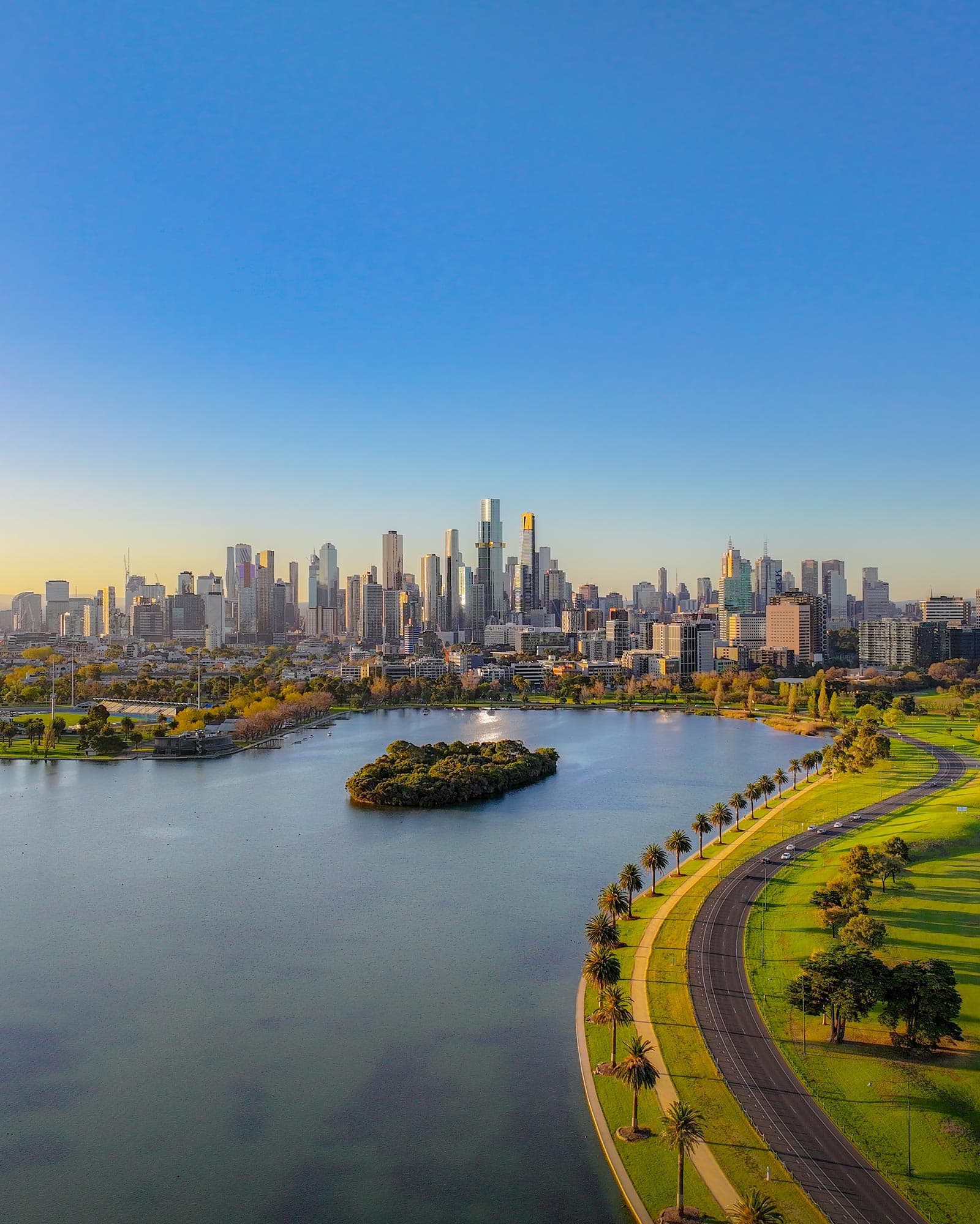 Albert Park Lake at golden hour, skyline reflected in still water